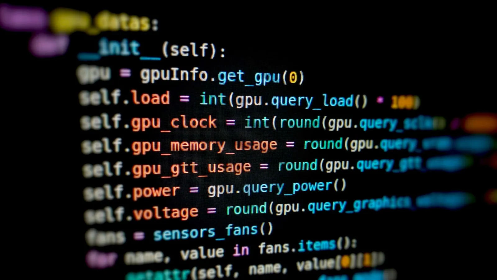 Colourful source code on a dark screen, shot at a shallow angle